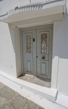 Eski ahşap çift kapılı süslü mermer çerçeveli ve geleneksel Chora, Andros, Greec evlerinde basamaklar
