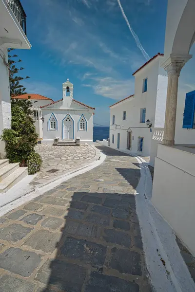 Andros Adası 'ndaki bulutlu gökyüzünün altında mavi detayları ve çan kulesiyle Beyaz Rum Ortodoks Kilisesi