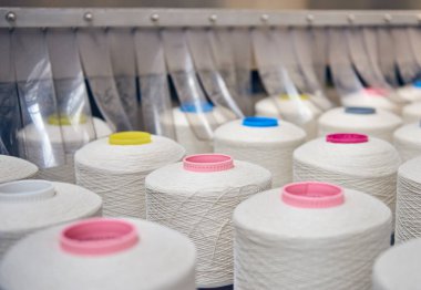 Bir dokuma fabrikasında bir makineye konan beyaz pamuk parçaları moda ve tekstil endüstrisi için pamuk dokuma makinesi. İplik, geleneksel kumaş kumaş imalatı için kumaş dokuyor.