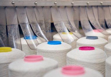 Bir dokuma fabrikasında bir makineye konan beyaz pamuk parçaları moda ve tekstil endüstrisi için pamuk dokuma makinesi. İplik, geleneksel kumaş kumaş imalatı için kumaş dokuyor.