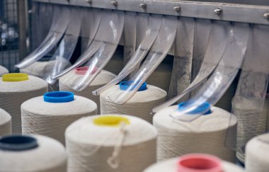 Bir dokuma fabrikasında bir makineye konan beyaz pamuk parçaları moda ve tekstil endüstrisi için pamuk dokuma makinesi. İplik, geleneksel kumaş kumaş imalatı için kumaş dokuyor.