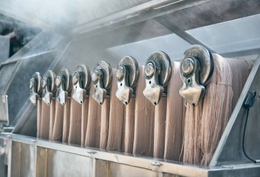 Endüstriyel bir makine, çiğ pamuk boyası sıcak sıcak suya batırma kumaş ve moda endüstrisi için çeşitli renklere pamuk boyama. Çiğ pamuk, makine için hazırlanıyor..