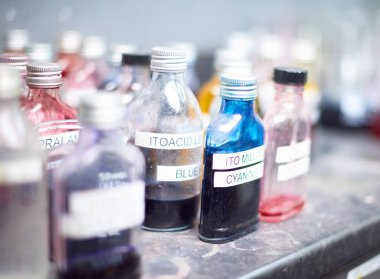 Kumaş ve endüstriyel boyama pamuk labratuvarı fabrikasında kimyasal boya ekipmanları ve beherler. Moda endüstrisi için ölen kumaşlar. Cam şişeler ve şişeler..