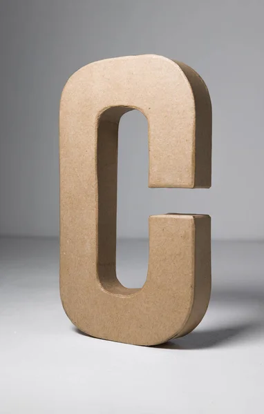 A 3d card letter C, alphabet and type card board cutout out. three dimensional letter shapes and moulds.