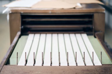 Tekstil fabrikasında çalışan elastik bel bantları yapan bir dikiş makinesi. Metal pamuk dikiş makinesi endüstrisi. Pamuk dikiş ve imalat tekstil endüstrileri. 