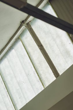 Endüstriyel imalat fabrikasının çatı penceresi. Retro ve klasik işyerleri. Pencere ve güneş ışığı güneşten gelir..