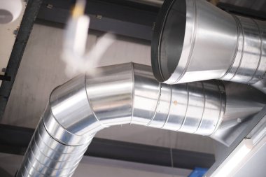 Endüstriyel metal hava akışı ve endüstriyel bir fabrikanın tavanında havalandırma boruları. Sağlık ve güvenlik için havayı temiz ve temiz tutmak. İşçi hakları için sağlıklı bir çalışma ortamı.