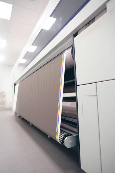 Industrial printing Cyan magenta yellow black and pink colour inkjet and laser jet ink industrial printing machine in a print house. Mass bulk printing.