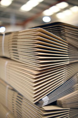 Üretimden yeni çıkmış bir yığın hazırlıksız kahverengi kart kutusu. Karton kutu depolama ve taşıma çözeltisi bir karton kutu fabrika deposu dağıtım