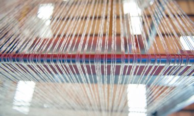 Bir dokuma fabrikasında pamuk iplikleri, moda ve tekstil endüstrisi için pamuk dokuma makinesi. Giysi ve moda için geleneksel tekstil kumaş üretimi iplik dokuması