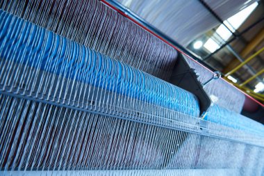 Bir dokuma fabrikasında pamuk iplikleri, moda ve tekstil endüstrisi için pamuk dokuma makinesi. Giysi ve moda için geleneksel tekstil kumaş üretimi iplik dokuması