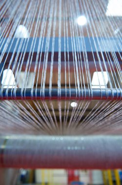 Bir dokuma fabrikasında pamuk iplikleri, moda ve tekstil endüstrisi için pamuk dokuma makinesi. Giysi ve moda için geleneksel tekstil kumaş üretimi iplik dokuması