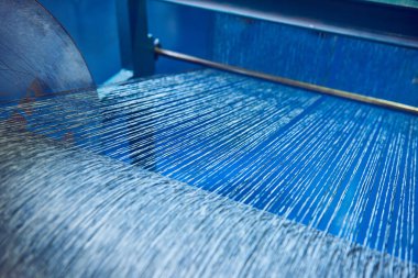 Bir dokuma fabrikasında pamuk iplikleri, moda ve tekstil endüstrisi için pamuk dokuma makinesi. Giysi ve moda için geleneksel tekstil kumaş üretimi iplik dokuması