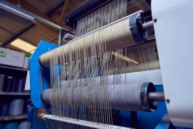Bir dokuma fabrikasında pamuk iplikleri, moda ve tekstil endüstrisi için pamuk dokuma makinesi. Giysi ve moda için geleneksel tekstil kumaş üretimi iplik dokuması