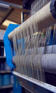 Bir dokuma fabrikasında pamuk iplikleri, moda ve tekstil endüstrisi için pamuk dokuma makinesi. Giysi ve moda için geleneksel tekstil kumaş üretimi iplik dokuması