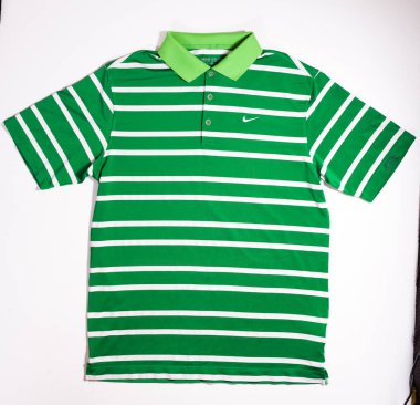 Kent, Uk 01.01.2023 yeşil çizgili golf topu tişörtü. Beyaz arka planda polo tişörtünün üzerindeki ünlü Nike Tik logosu. Nike spor yıldızlarına sponsor oluyor.