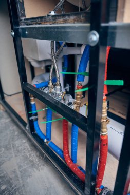 Londra, İngiltere, 10.10.10.2022 Kompleks sıcak ve soğuk musluk su boruları prefabrik odalarda kullanılır. Kazan, lavabo, banyo, duş ve tuvaletlerde su basıncı. Endüstriyel hizmet endüstrisi.