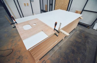 Ahşap marangozluk işi banyo aletleri ve yüzeyler için kesme işi. Musluk için lavabo şekilleri kesmek ve banyo kapaklarında boru delikleri açmak. Sanayi kitlesi marangozluk üretiyor. 