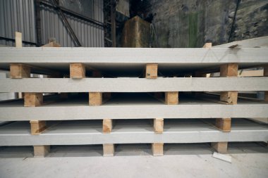 Fabrika ortamında alçıpan alçıpan levhaları. İnşaat ve inşaat endüstrisi için sanayi tipi alçı malzemeler. Sıva ve doğrama malzemeleri. Ev geliştirmeleri 