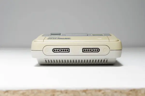 stock image london, uk 03.03.2020 Nintendo snes super nintendo official original video game console,  cartridge slot on a white isolated background. iconic retro super famicon gaming machine. 