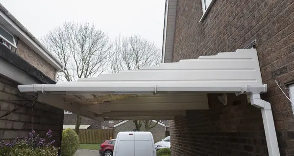 stock image Cleaned white plastic pvc gutters and drain pipes that were blocked and full of green mould on the plastic fascias.  Blocked drains and guttering need window cleaners and regular maintenance for good drainage.