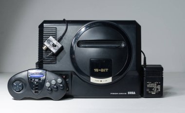 Londra, İngiltere, 02.03.2021 Sega megadrive 16 bit konsol güç adaptörü ve üçüncü parti kontrolörü. Orijinal antika oyun konsolu. Retro oyun, bilgisayar oyunu geçmişi.