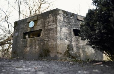 blackpool, uk 03.03.2021 A brutalist cold gritty concrete world war two, ww2, pillbox war bunker defence fortress in a dirty forgotten woodland. wartime relics and forgotten outpost s. clipart