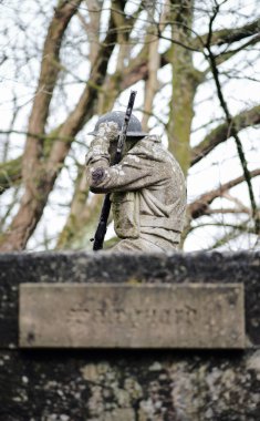 blackpool, uk, 05.02.2021 A gritty concrete world war two air raid soldier sculpture on top of a war bunker defence fortress in a dirty forgotten woodland in europe. wartime conflict relics. clipart