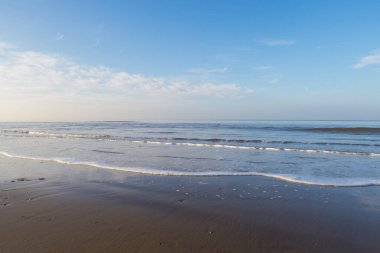 Gün batımında canlı mavi bir gökyüzü ve yansımasıyla plaja akan rahatlatıcı ve nazik dalgalar. Corona virüsünün kilitlenmesi sırasında temiz hava doğaya karışıyor.