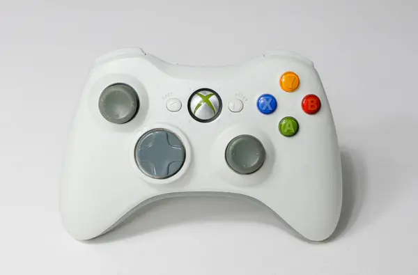 Stock image london, uk 05/05/2020 An white futuristic microsoft  xbox 360 controller on a white studio backdrop. collectable rare home arcade video gaming. joystick and wireless remote technology.