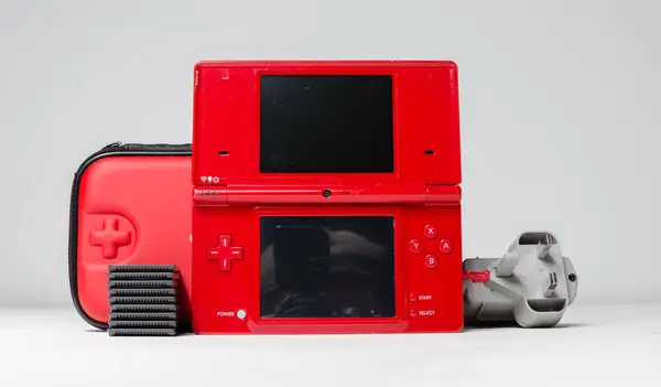 stock image lodnon, england, 05/05/2019 A gloss red nintendo ds i hand held vintage console on a white studio background. Retro video gaming handset. nostalgic computer and arcade games. 