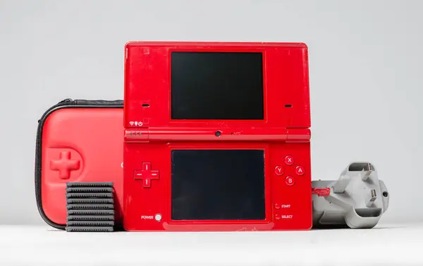 stock image lodnon, england, 05/05/2019 A gloss red nintendo ds i hand held vintage console on a white studio background. Retro video gaming handset. nostalgic computer and arcade games. 