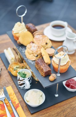 Organik kekler, çay ve kahve, çilek reçeli ve pıhtılaşmış kremayla servis edilen güzel bir İngiliz çay keki ve çörekleri. Geleneksel İngiliz yemekleri.