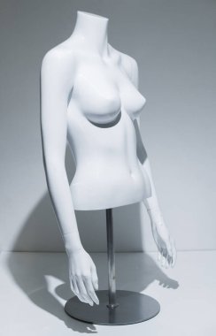 Ayarlanabilir kolları ve beyaz göğsü olan bir kadın manken gövdesi. Metal direkte ve zeminde büst görüntüsü. Perakende satış mağazaları için moda modeli. Perakende gösterimi.