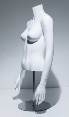 Ayarlanabilir kolları ve beyaz göğsü olan bir kadın manken gövdesi. Metal direkte ve zeminde büst görüntüsü. Perakende satış mağazaları için moda modeli. Perakende gösterimi.