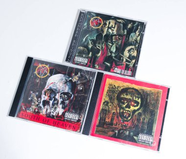 Kent, UK, 01.01.2023 Beyaz arka planda 3 avcı cd 'si. Cennetin güneyinde, kanla hüküm sürerken, uçurumda mevsimler geçirirken. Klasik temiz metal rock müzik CD 'leri. death metal sesleri.