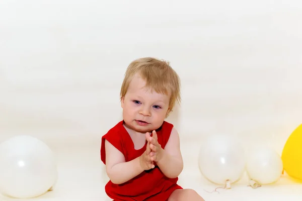 Egy Éves Kisgyerek Szőke Hajjal Piros Testviseletben Fehér Háttéren Ülve — Stock Fotó