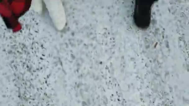雪の中を歩くブーツの女の子とマンションの足 人間の足は 痕跡を残して雪の上にあり 去っていきます 高品質の4K映像 — ストック動画