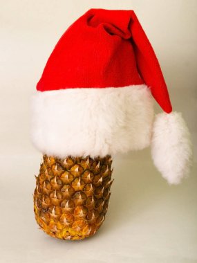 Yeni yıl kompozisyonu ahşap bir arka planda. Yeni yıl şapkası, ananas ve mandalina. Noel Baba şapkası. Noel konsepti.