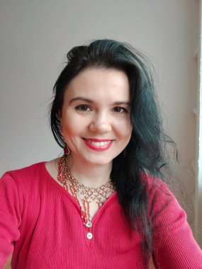 Kırmızı elbiseli bir dansçı beyaz arka planda doğulu bir dans ediyor. Profesyonel bir dansçı oryantal göbek dansı yapar. Kırmızı elbiseli seksi kadın beyaz bir stüdyoda baştan çıkarıcı bir dans yapıyor.