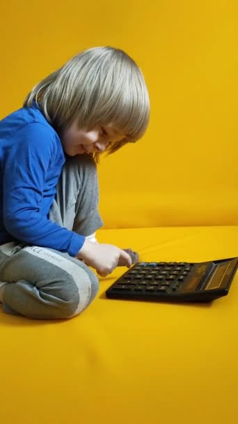 Malé Dítě Počítá Kalkulačkou Žlutém Pozadí Kluci Mačkají Knoflíky Doma — Stock video