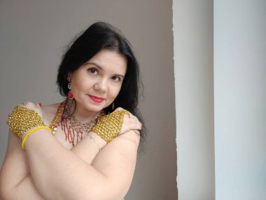 Kırmızı elbiseli bir dansçı beyaz arka planda doğulu bir dans ediyor. Metin için boş alan. Pankart. Profesyonel bir dansçı oryantal göbek dansı yapar. Kırmızı elbiseli seksi kadın baştan çıkarıcı danslar yapıyor.