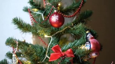 Mutlu yıllar Noel ağacı, arka plandaki kırmızı cam top ile süslenir. Aile tatili için yanıp sönen ampuller. Festival havası. Pozitif duygu