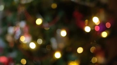 Mutlu yıllar Noel ağacı, arka plandaki kırmızı cam top ile süslenir. Aile tatili için yanıp sönen ampuller. Festival havası. Pozitif duygu
