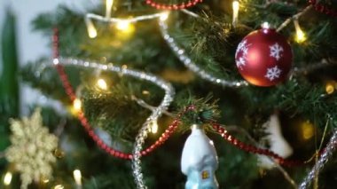 Mutlu yıllar Noel ağacı, arka plandaki kırmızı cam top ile süslenir. Aile tatili için yanıp sönen ampuller. Festival havası. Pozitif duygu