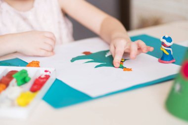 Making handmade Christmas cards. Childrens DIY concept. Little girl doing Christmas tree decoration or greeting cards from plasticine. Crafts for children
