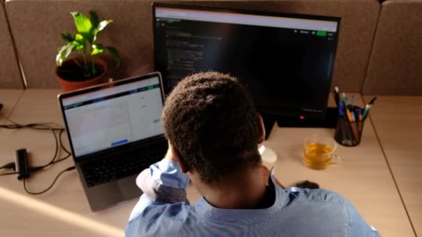 黑衣人在台式机上写下代码行 有两名监督员和一台笔记本电脑在文具柜办公室外 创业公司的专业男性开发人员编程人工智能软件 — 图库视频影像