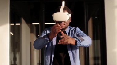 VR kulaklıklı bir adam metaevren dünyasını keşfediyor, sanal gerçeklik deneklerine dokunuyor. Ofiste soyut siber dünya.