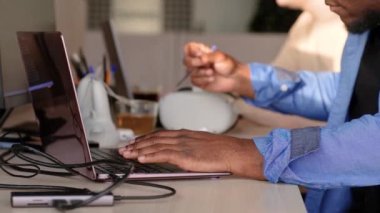 Close up of a young african freelancer man hands typing, working on laptop keyboard for send emails and surf on a web browser. 