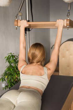 Pilates fitness antrenörü pilates stüdyosunda egzersiz yapıyor. Spor salonunda spor yapmak için dengeli vücut Cadillac 'ı. Formda, sağlıklı ve güçlü özgün bir vücut. Fitness konsepti